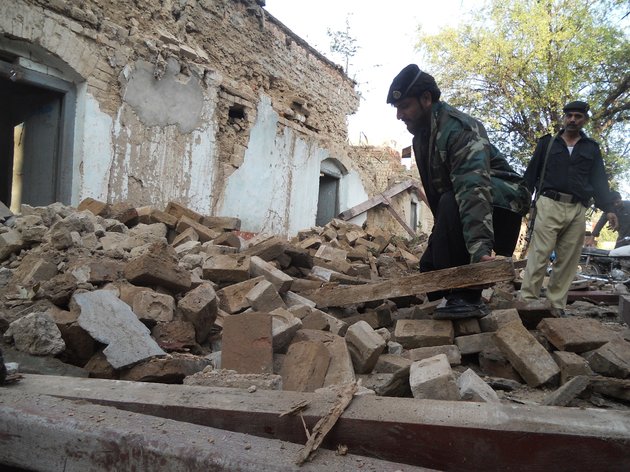 A Pakistani policeman digs through the debris of collapsed houses after an earthquake in Kohat on October 26, 2015. A powerful 7.5 magnitude earthquake killed at least 70 people as it rocked south Asia, including 12 Afghan girls crushed to death in a stampede as they tried to flee their collapsing school. AFP PHOTO / BASIT SHAH (Photo credit should read BASIT SHAH/AFP/Getty Images)