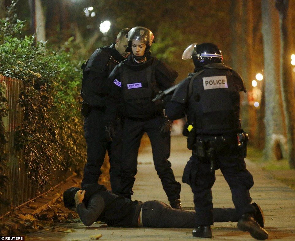 A man lies on the ground as French police check his identity near the Bataclan concert hall following a series of terror attacks in Paris.