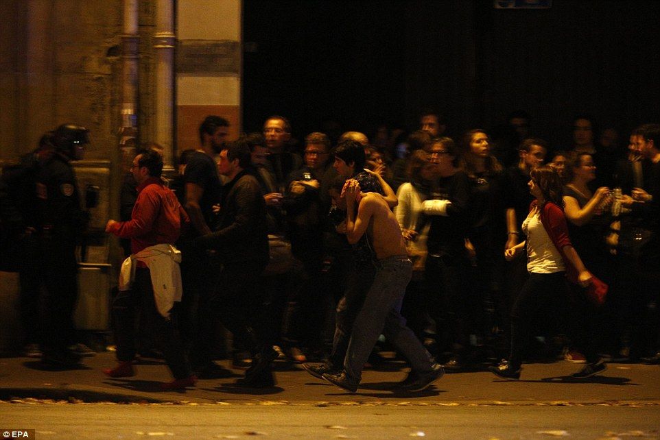 People gather at the scene of a hostage situation at the Bataclan theater in Paris, where around 100 people are being held inside.