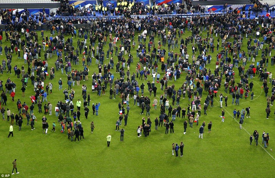 Spectators invade the pitch of the Stade de France stadium after two explosions were heard during the international friendly soccer France against Germany.